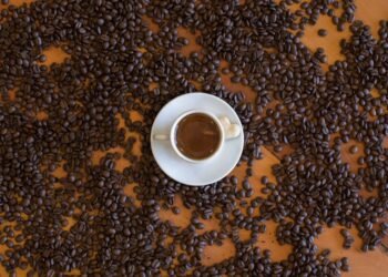 Taza de café sobre granos. Imagen PEXELS.