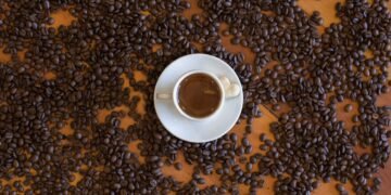 Taza de café sobre granos. Imagen PEXELS.