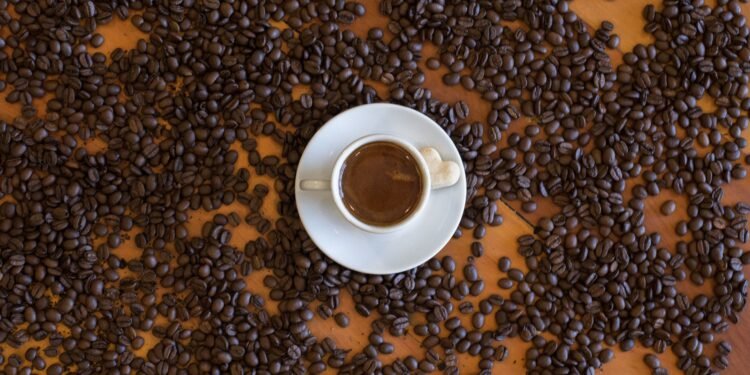 Taza de café sobre granos. Imagen PEXELS.