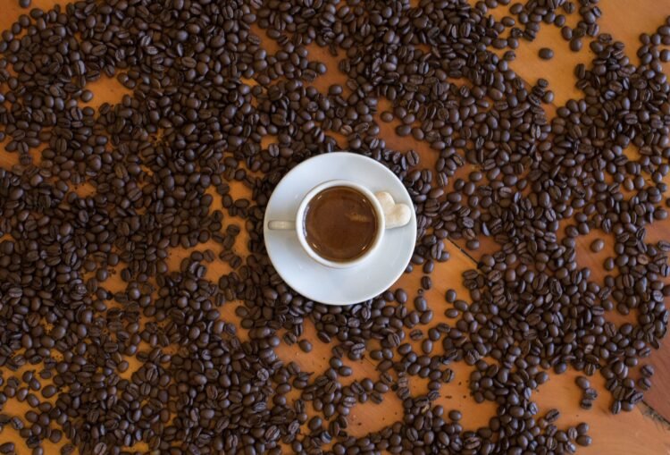 Taza de café sobre granos. Imagen PEXELS.
